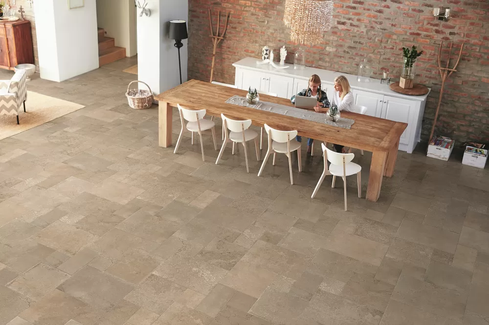 Big dinning room with beige terracotta floor and long dinning table