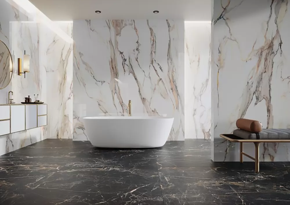 Large bathroom with calacatta walls and black marquina floor. Bathtub in the middle and sink on the left.